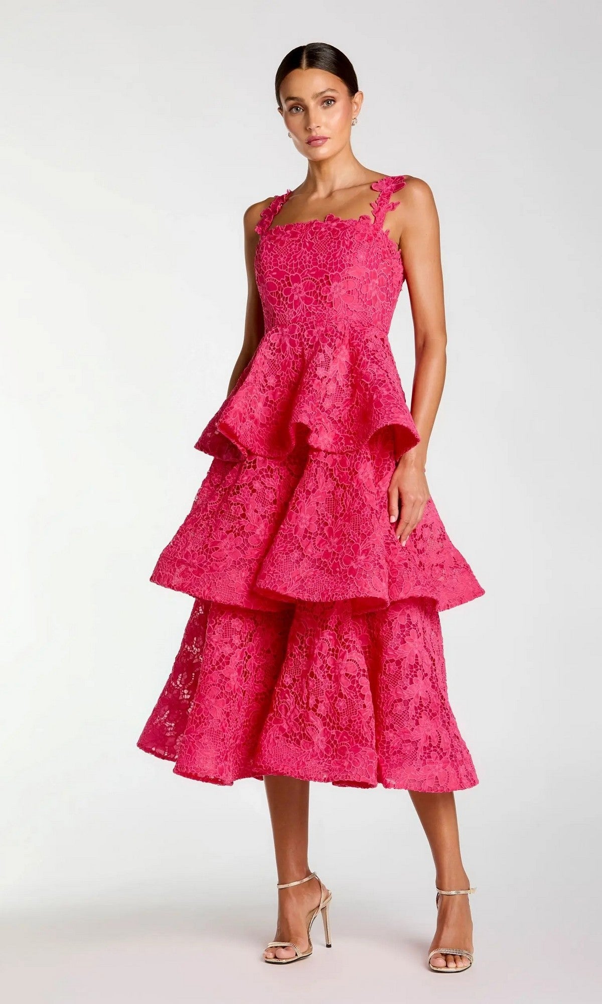 A woman wearing the Mac Duggal 56322 Midi Party Dress in hot pinkโa sleeveless party dress featuring tiered lace embroidery and a square necklineโstands against a plain light background in strappy high-heeled sandals for a chic look.